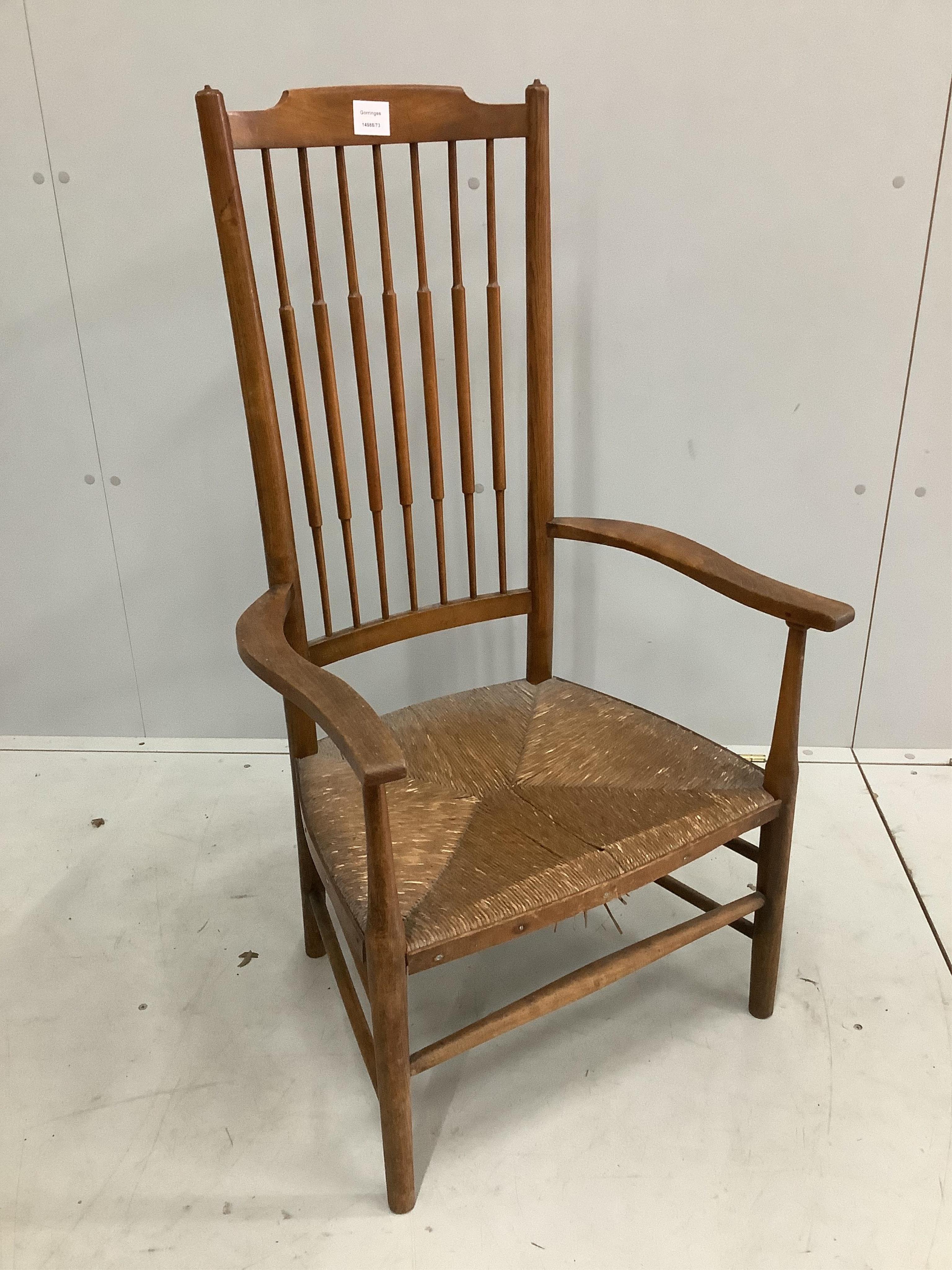 An Arts & Crafts ash and beech rush seat spindle back elbow chair, width 54cm, depth 42cm, height 102cm. Condition - fair